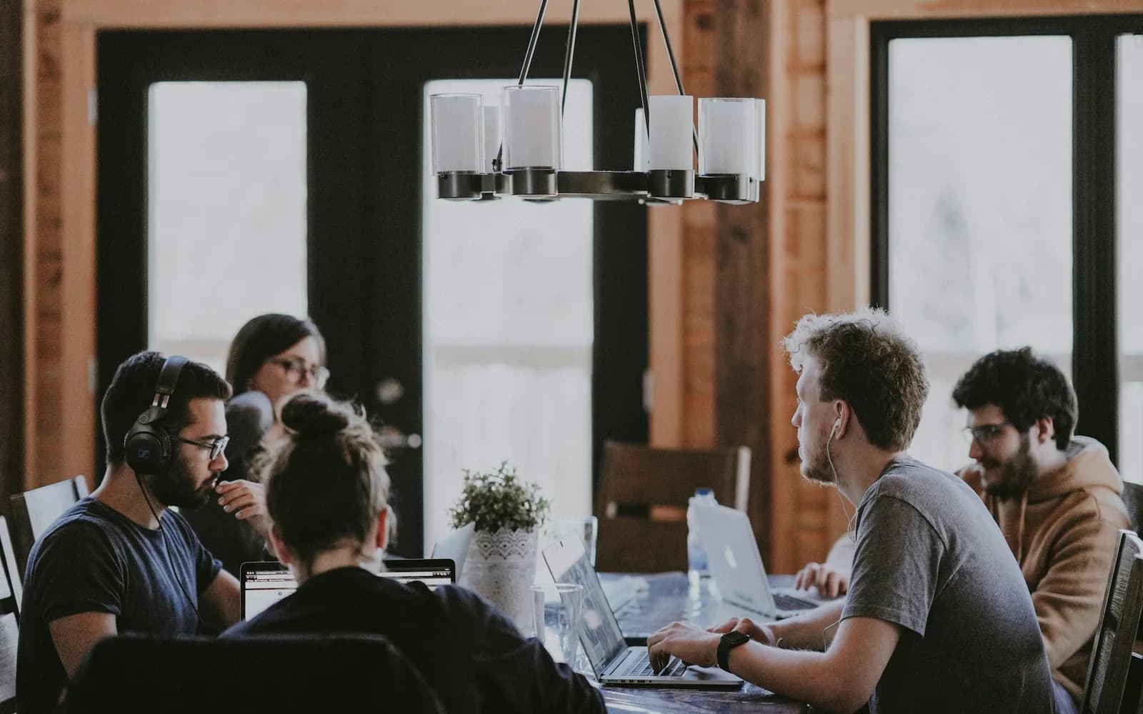 A creative team collaborating around a table with laptops